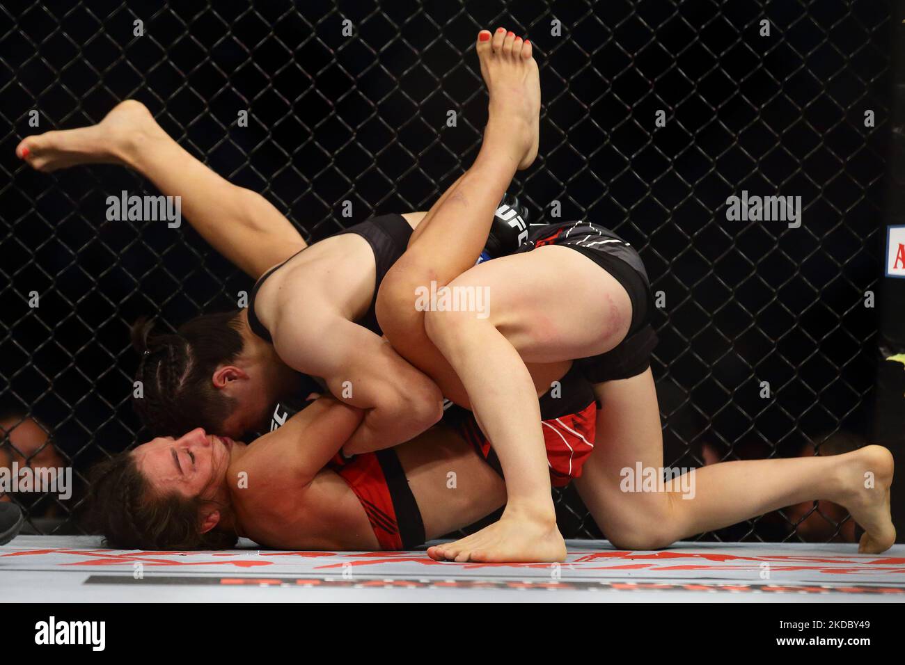 Zhang Weili, de Chine (en haut), combat Joanna Jedrzejczyk, de Pologne, dans le cadre de la bataille de poids-paille des femmes, lors de l’événement UFC 275 au stade intérieur de Singapour, à 12 juin 2022, à Singapour. (Photo de Suhaimi Abdullah/NurPhoto) Banque D'Images