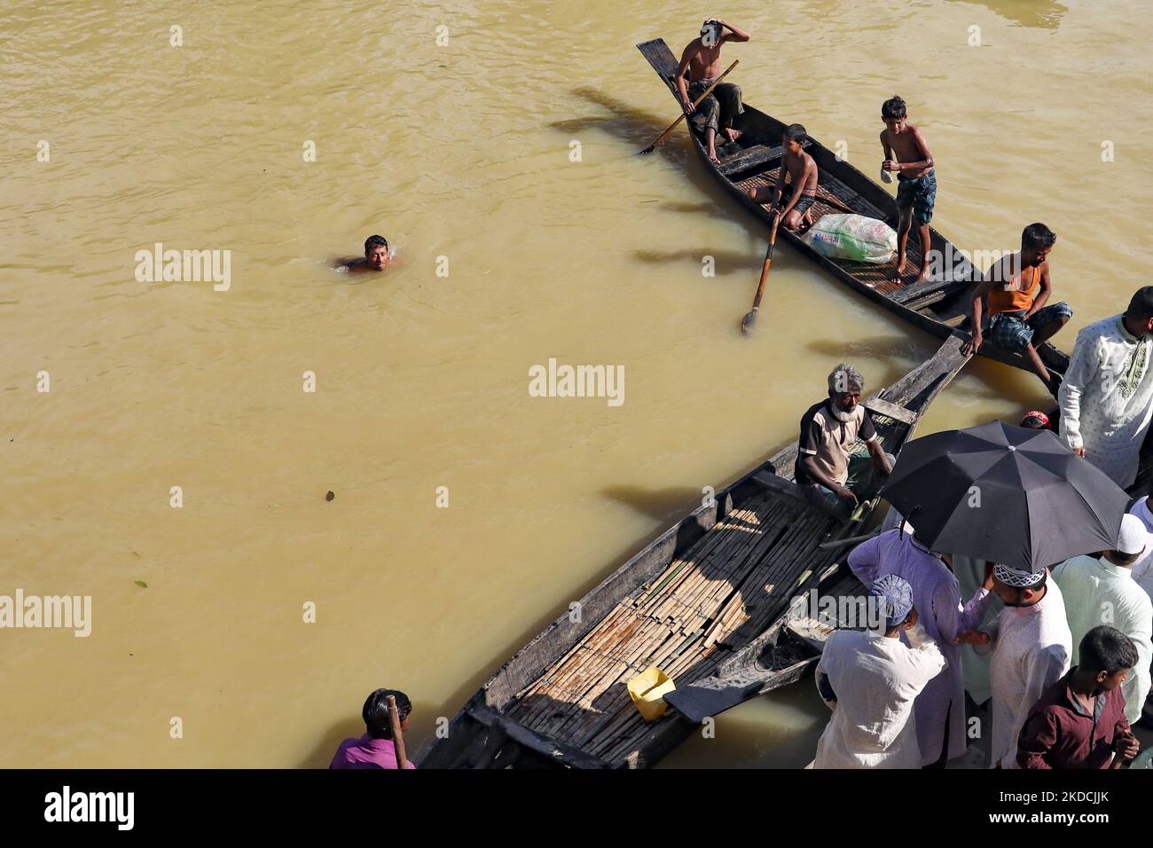 Un homme affecté par une inondation se baigner dans l'eau inondée pour recueillir des médicaments et du matériel de secours pour les personnes touchées par une inondation à Sylhet, au Bangladesh, sur 24 juin 2022. (Photo de Kazi Salahuddin Razu/NurPhoto) Banque D'Images