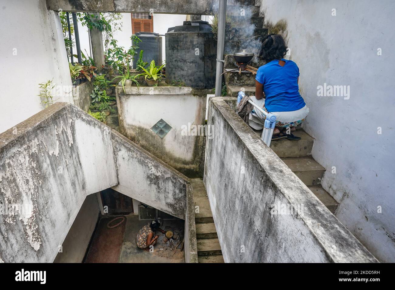 En raison de la grave crise du gaz au Sri Lanka, les personnes vivant dans des appartements dans les zones urbaines sont confrontées à beaucoup de problèmes. En raison du manque de gaz et de l'interdiction d'utiliser des poêles à bois dans les appartements, de nombreux propriétaires d'appartements ont recours à la cuisine extérieure. La photo montre deux femmes vivant dans un complexe de logements Colombo qui cuisent de la nourriture sur les escaliers, à 04 juillet 2022, à Colombo, au Sri Lanka (photo de Thilina Kaluthotage/NurPhoto) Banque D'Images