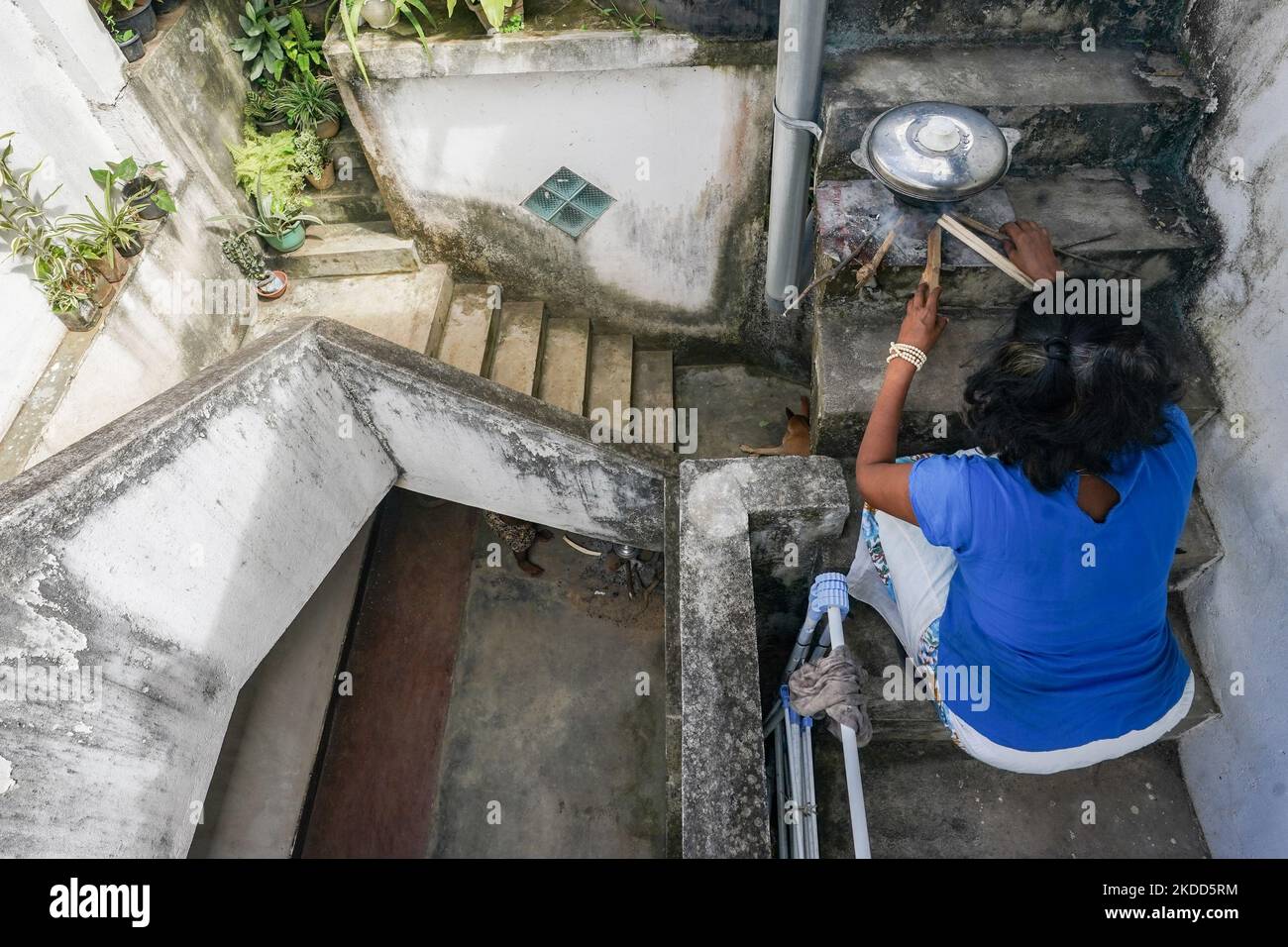 En raison de la grave crise du gaz au Sri Lanka, les personnes vivant dans des appartements dans les zones urbaines sont confrontées à beaucoup de problèmes. En raison du manque de gaz et de l'interdiction d'utiliser des poêles à bois dans les appartements, de nombreux propriétaires d'appartements ont recours à la cuisine extérieure. La photo montre deux femmes vivant dans un complexe de logements Colombo qui cuisent de la nourriture sur les escaliers. Sur 04 juillet 2022, à Colombo, Sri Lanka (photo de Thilina Kaluthotage/NurPhoto) Banque D'Images