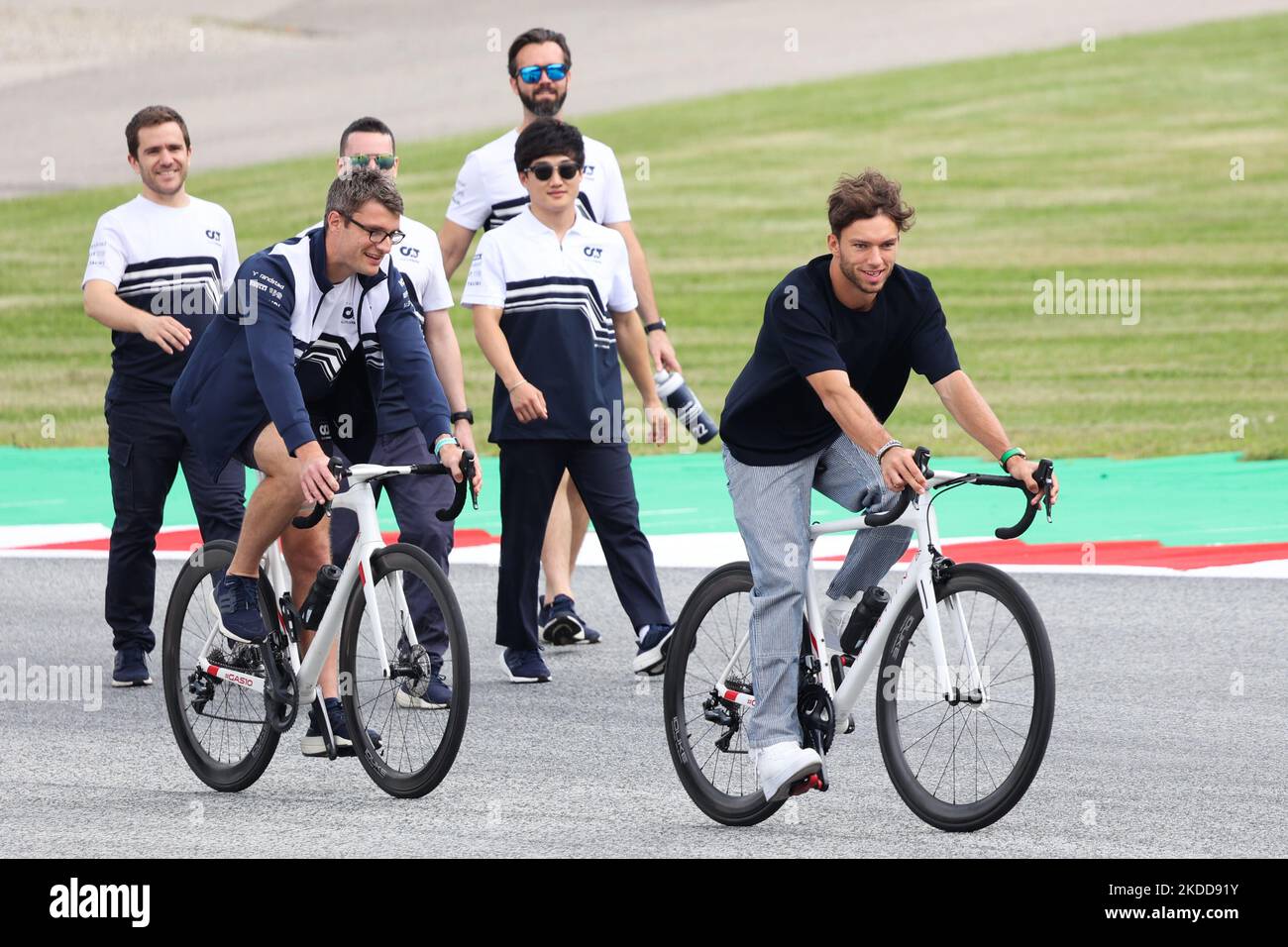 Pierre Gasly d'AlphaTauri-RBPT fait un vélo et Yuki Tsunoda  d'AlphaTauri-RBPT marche sur la piste devant le Grand Prix autrichien de  Formule 1 au Red Bull Ring à Spielberg, Autriche, sur 7 juillet