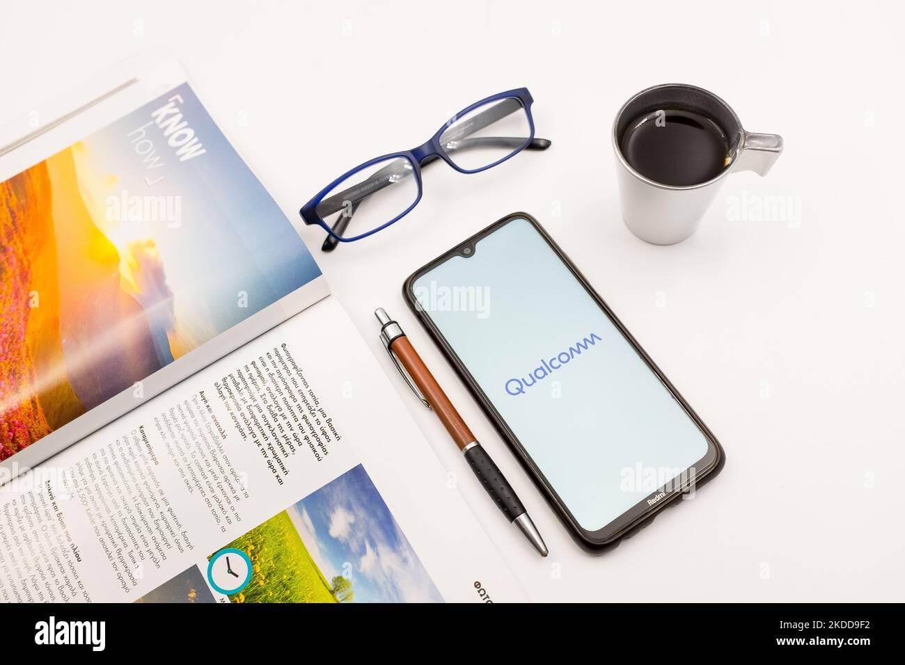 Sur cette photo, un logo Qualcomm apparaît sur l'écran d'un smartphone, sur un bureau à côté d'un café, d'un stylo, de lunettes et d'un magazine à Athènes, en Grèce, sur 7 juillet 2022. (Photo d'illustration par Nikolas Kokovlis/NurPhoto) Banque D'Images