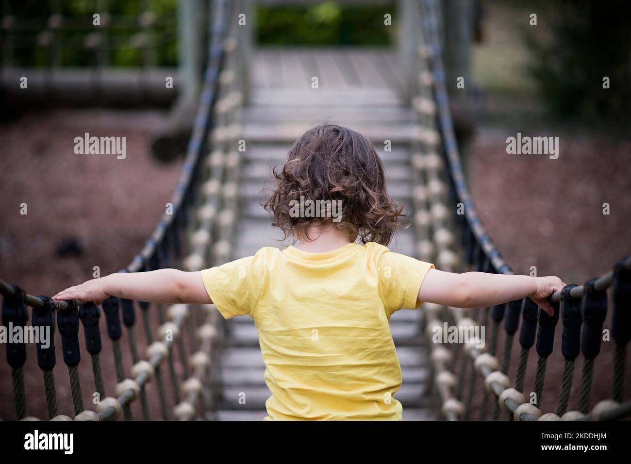 un jeune garçon surmonte ses peurs pour traverser le pont Banque D'Images