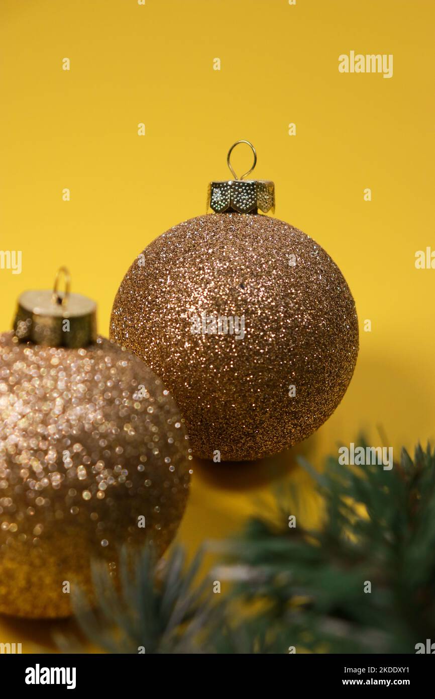 boules décoratives de Noël dorées sur fond jaune avec pin vert Banque D'Images