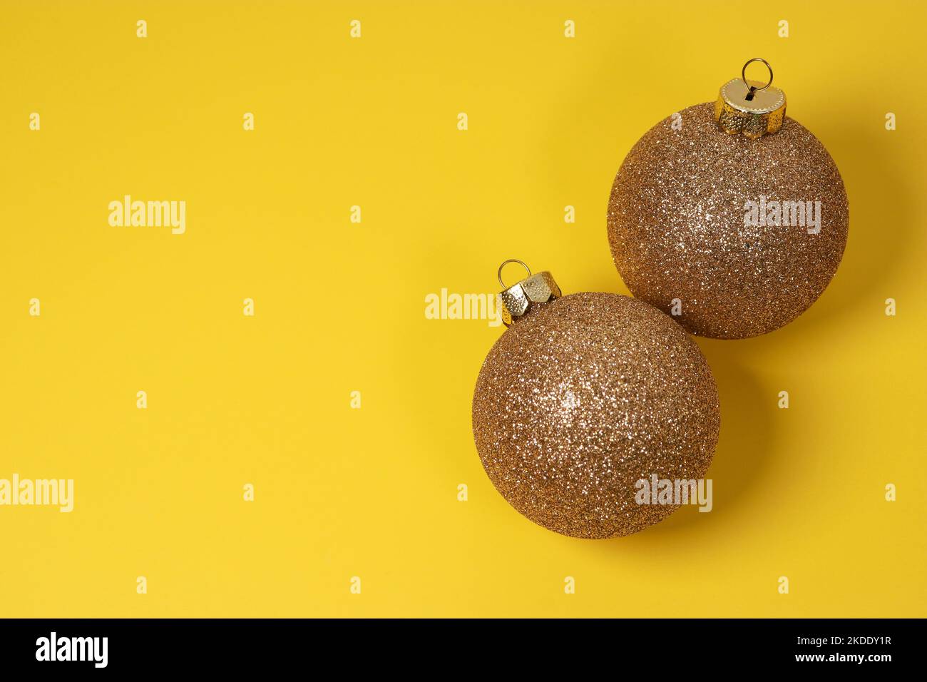 boules décoratives de Noël dorées sur fond jaune avec pin vert Banque D'Images