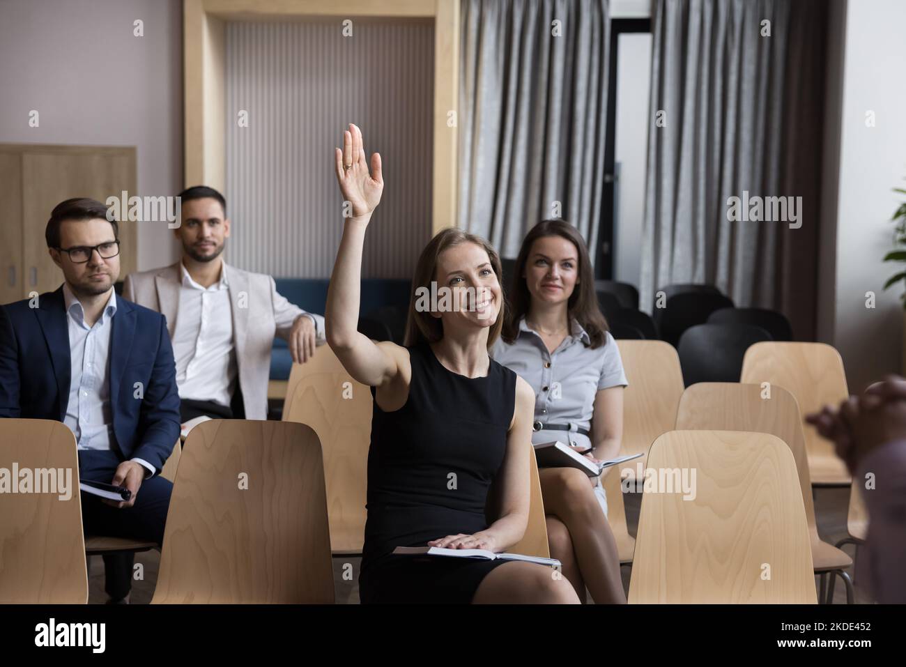 Femme employée, participant à la formation ayant des questions levez le bras pendant l'atelier Banque D'Images