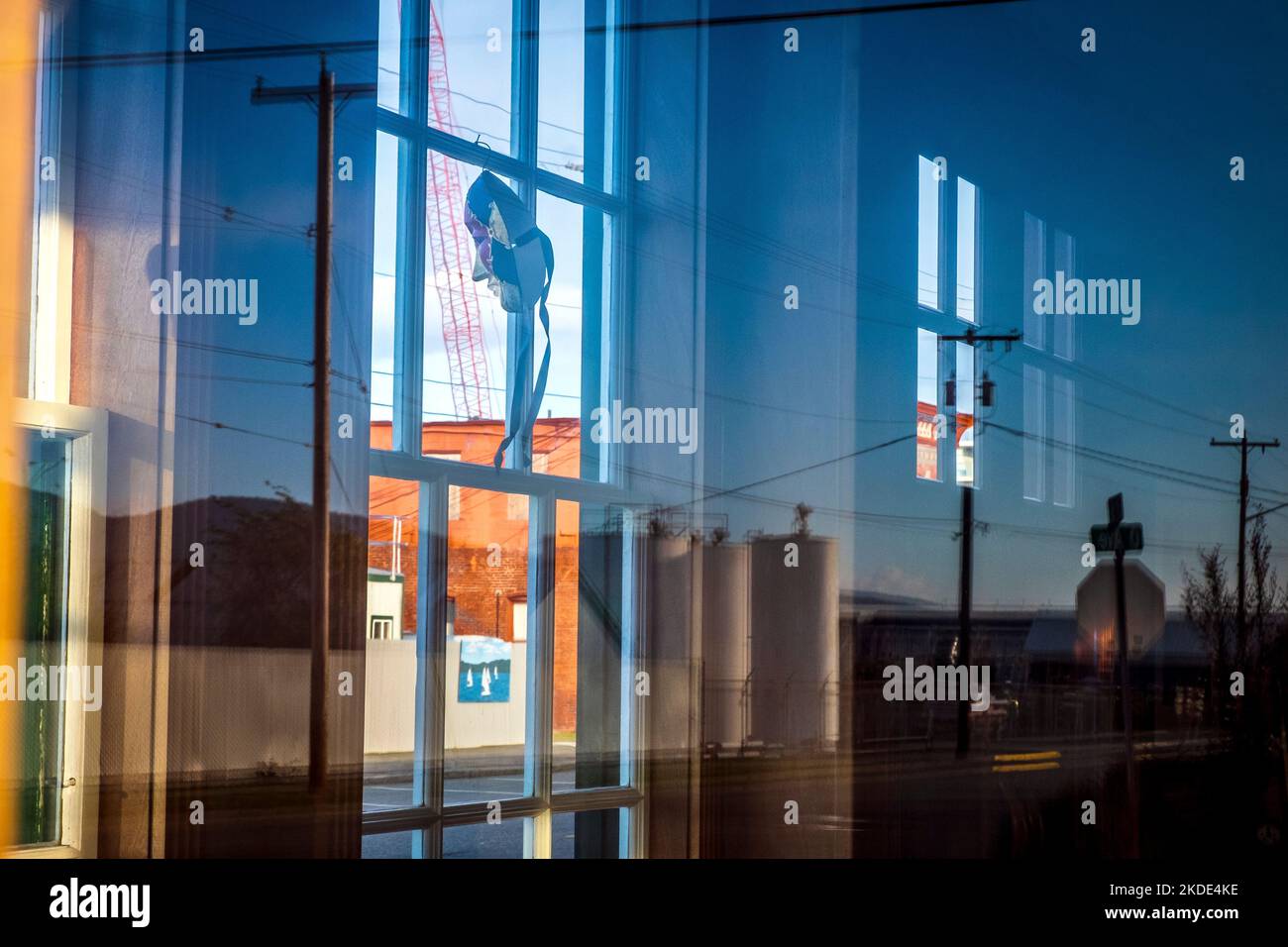 Masque féminin donnant sur une fenêtre bleue dans une petite ville Banque D'Images