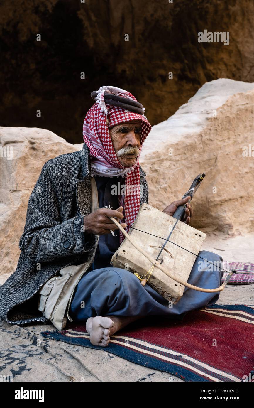 Siq el-Barid, Jordanie - 29 octobre 2022: Vieil homme bédouin jordanien jouant le violon à une chaîne de Rababah Banque D'Images