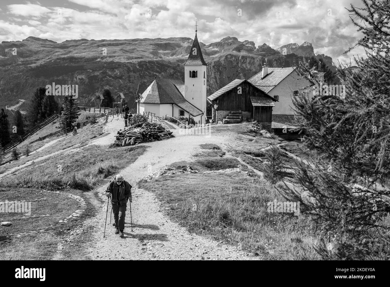 Un randonneur âgé dans les Alpes Dolomites, l'église Heilig Kreuz en arrière-plan, le Tyrol du Sud en Italie Banque D'Images