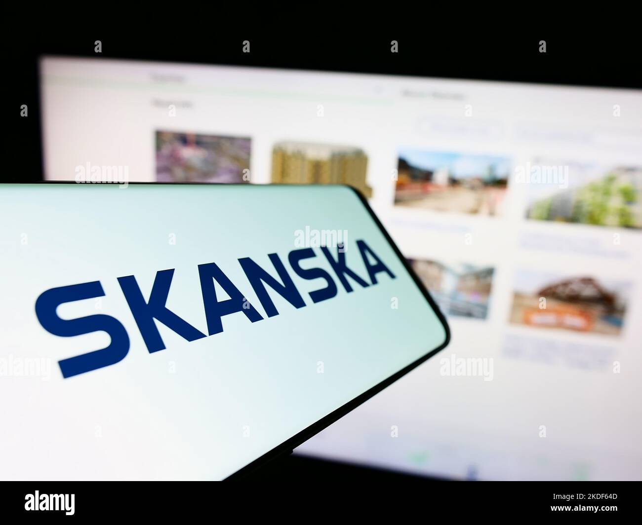 Téléphone portable avec logo de la société suédoise de construction Skanska AB à l'écran devant le site Web des affaires. Mise au point au centre-gauche de l'écran du téléphone. Banque D'Images