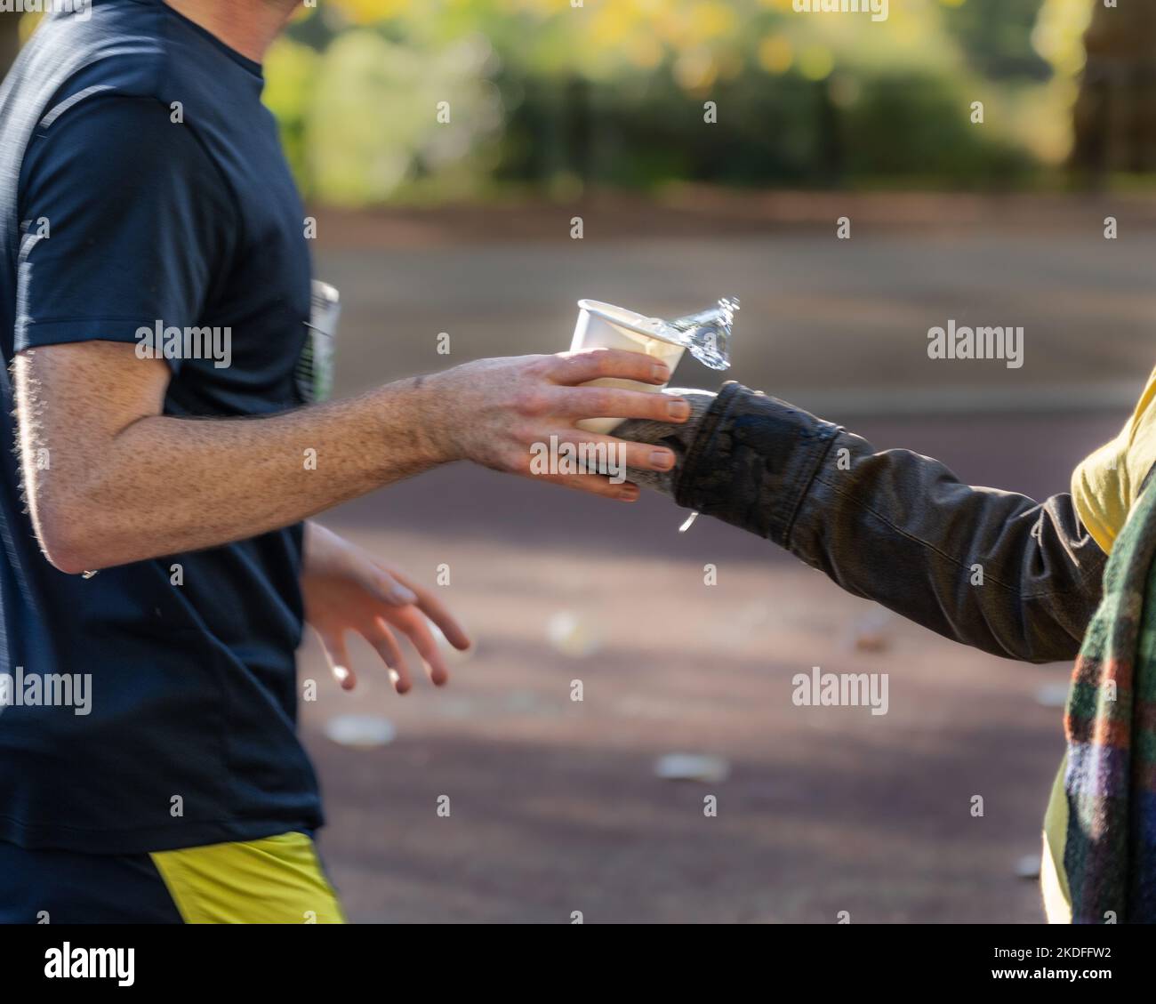 Des bénévoles distribuent des rafraîchissements aux coureurs lors d'un marathon Banque D'Images