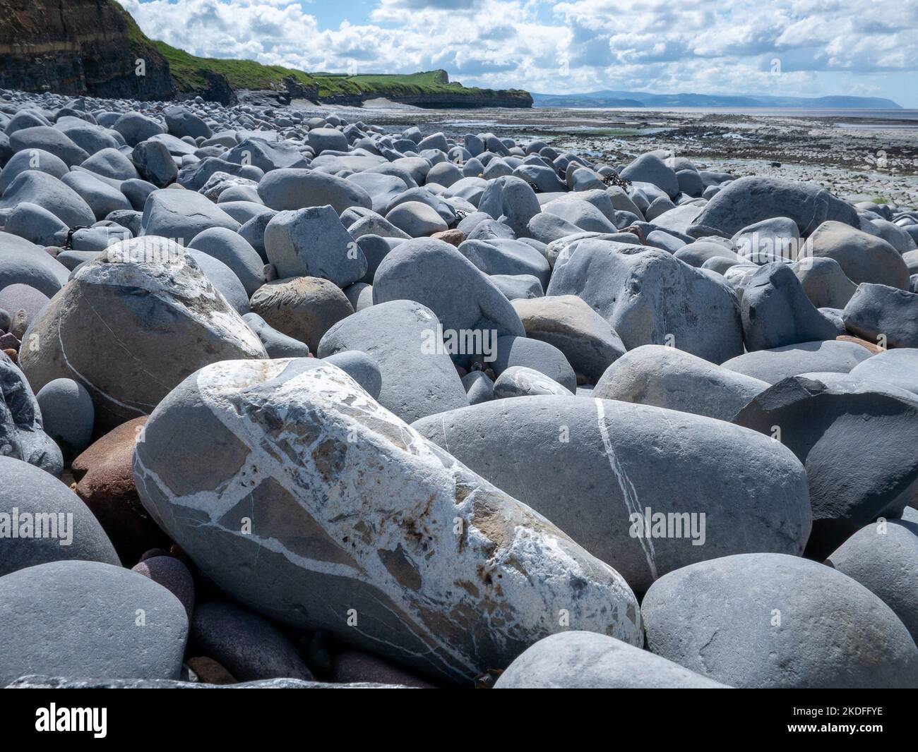 rochers sur une plage sous les falaises Banque D'Images