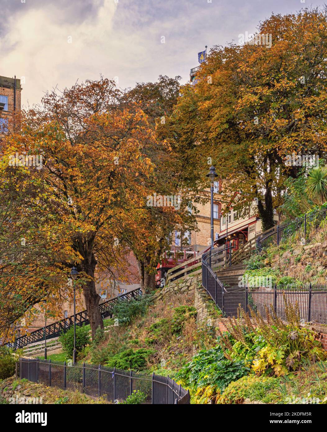 Les chemins de fer dans un jardin municipal mènent à un funiculaire avec un tramway. Des arbres d'automne bordent la colline. Banque D'Images