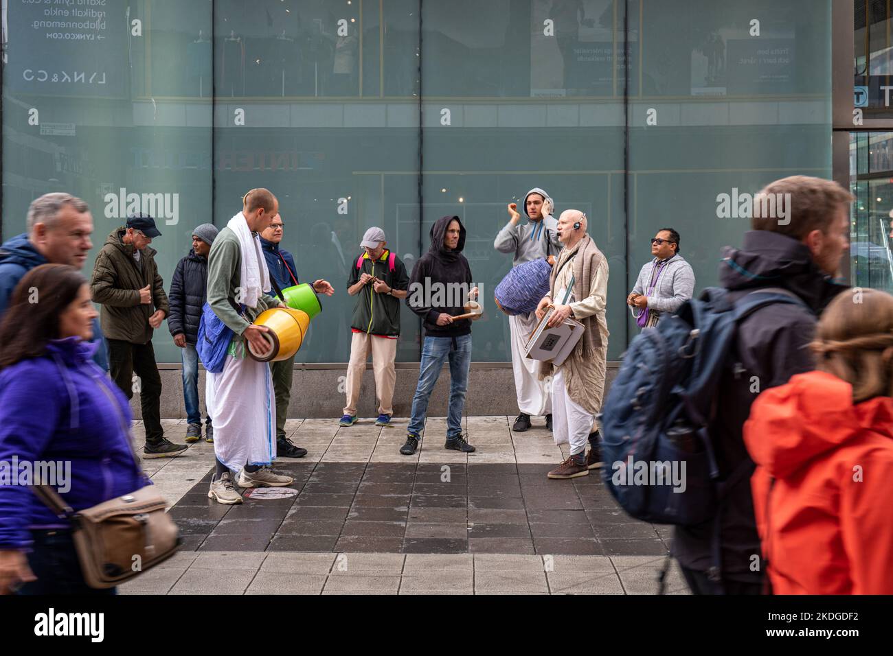Hare Krishnas chantant alors que les gens passent à Sergels torg à Stockholm, en Suède Banque D'Images
