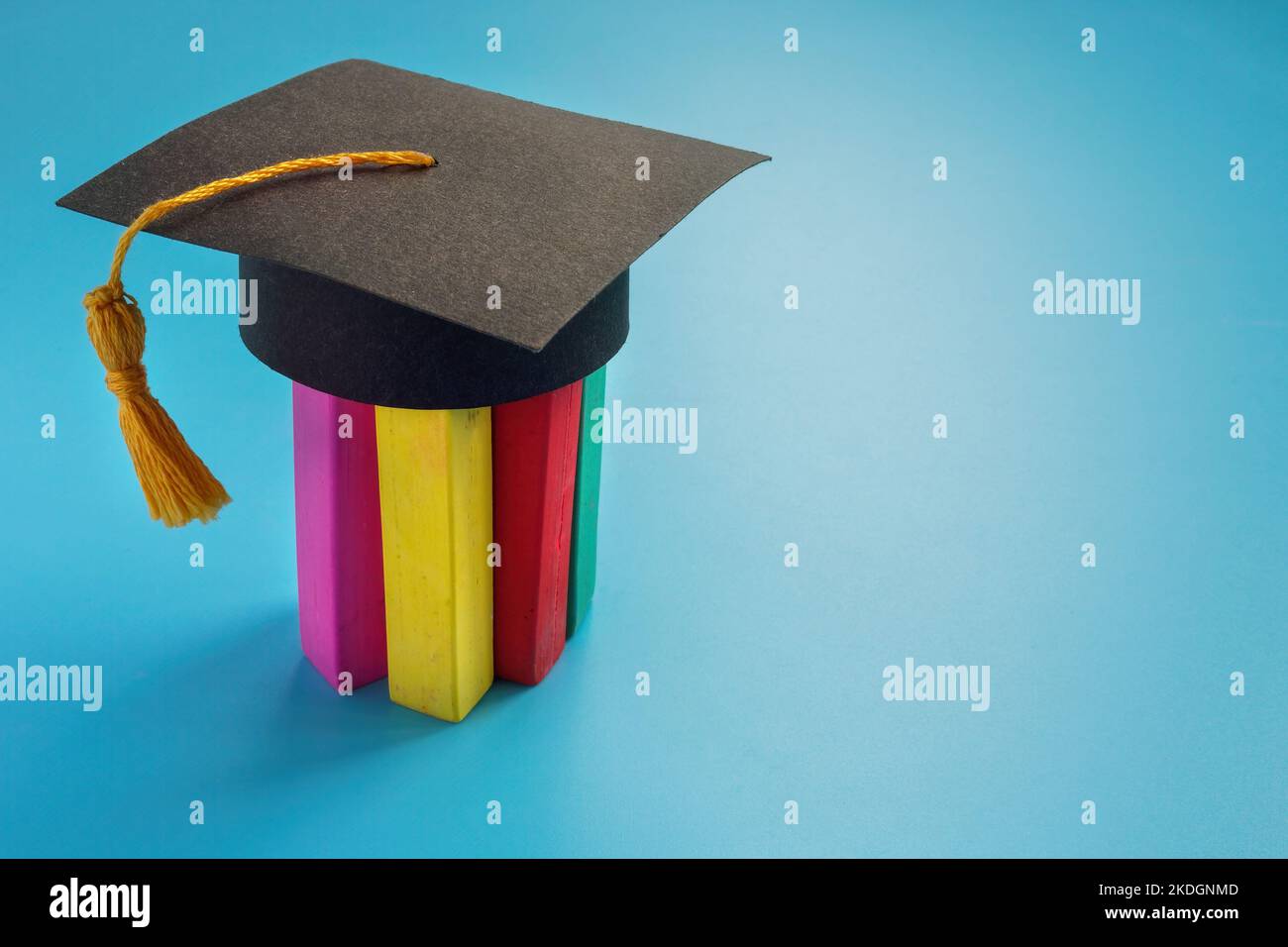 Éducation à l'inclusion et à la neurodiversité. Crayons de couleur sur lesquels un capuchon de graduation est porté. Banque D'Images