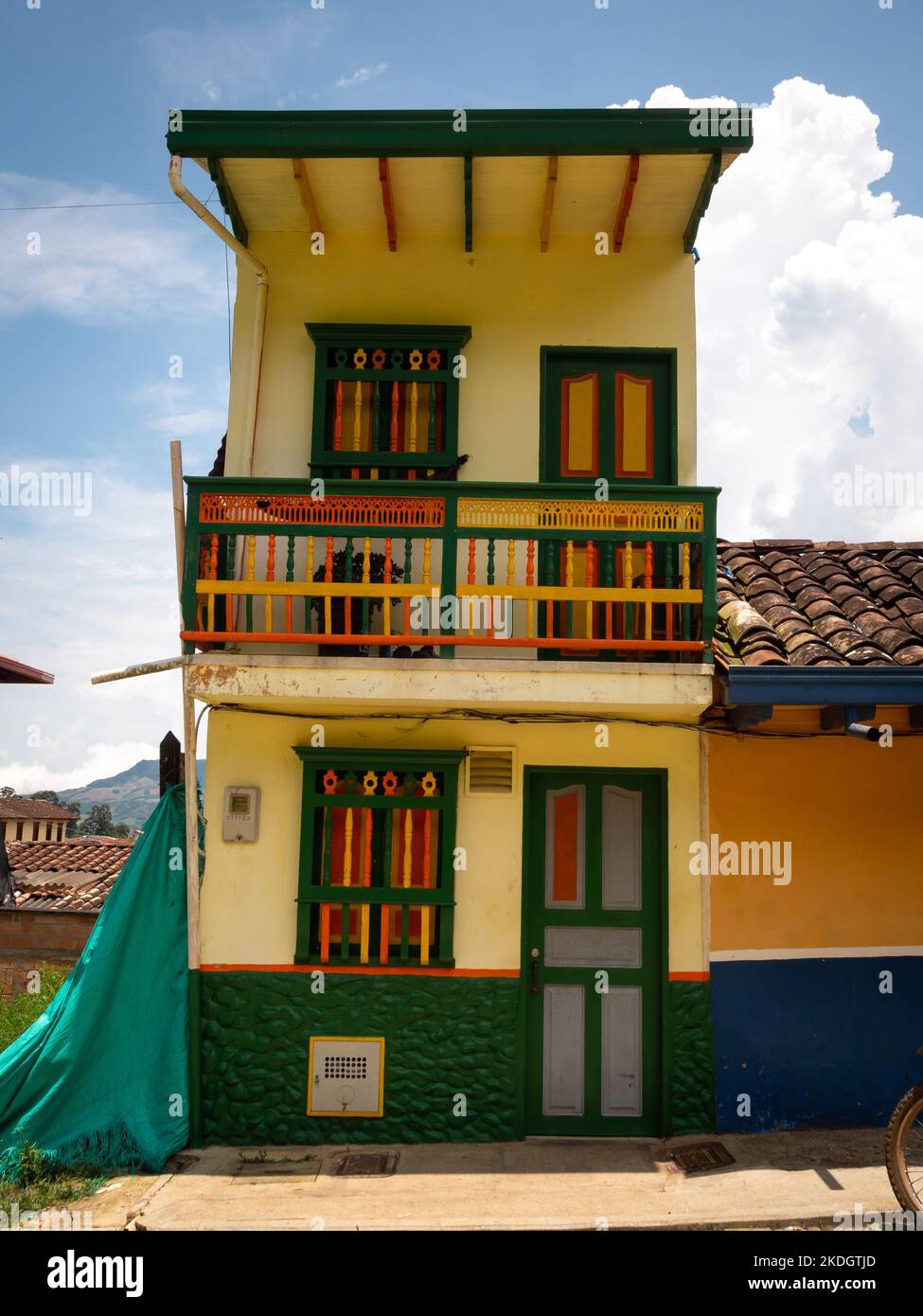 Jerico, Antioquia, Colombie - 5 avril 2022: Blanc minuscule style colonial maison de deux étages avec portes et fenêtres en bois peint vert Banque D'Images