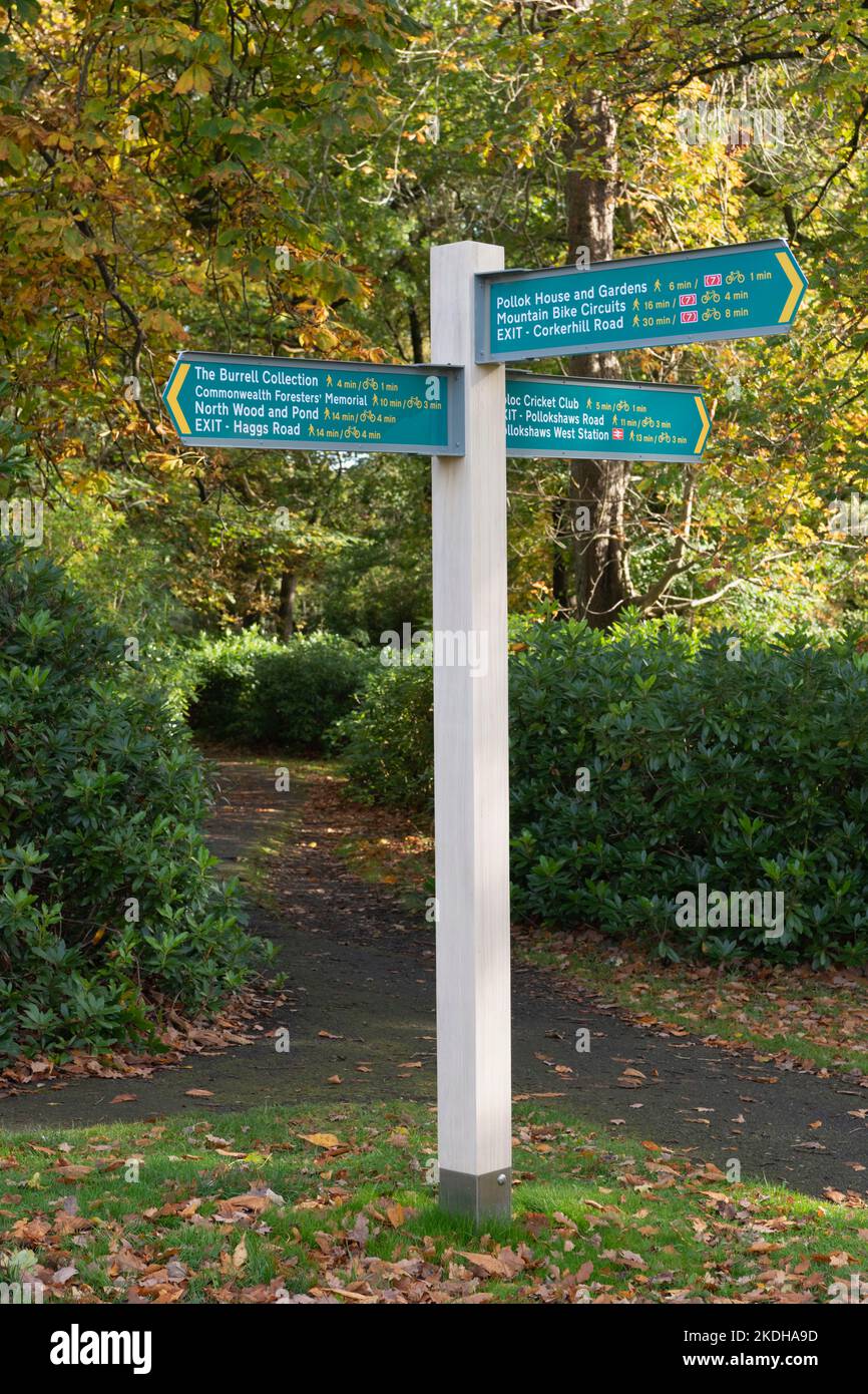 Un poste de signalisation dans le parc régional de Pollok, Glasgow, indiquant la direction et les distances jusqu'à diverses destinations Banque D'Images