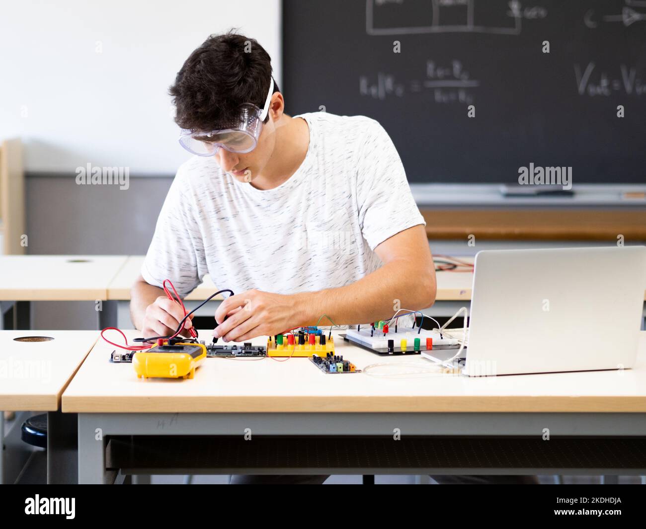 Jeune étudiant expérimenté avec des appareils électroniques dans le laboratoire Banque D'Images