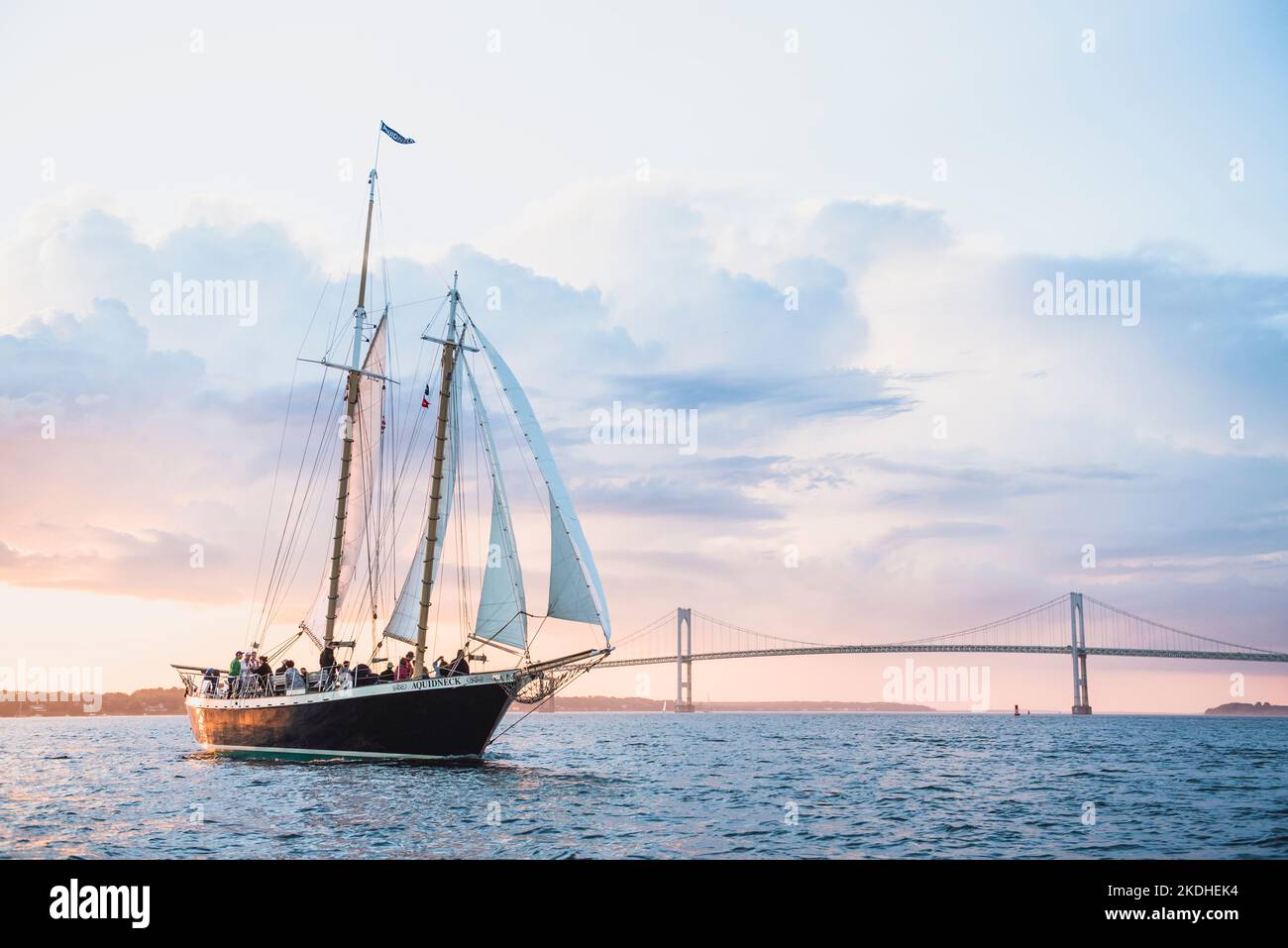 La goélette Aquidneck et le pont de Newport pendant la location de coucher de soleil d'été Banque D'Images
