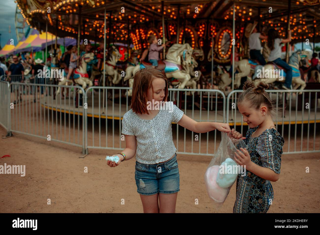 Deux jeunes filles partagent un sac de bonbons en coton lors d'un carnaval Banque D'Images