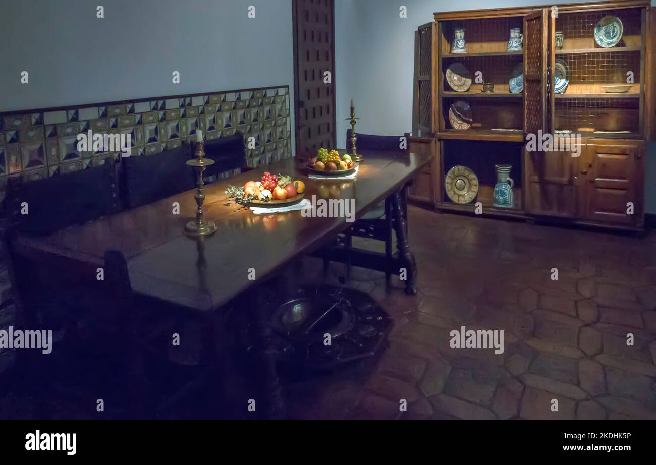 Ancienne cuisine ancienne salle à manger avec table et assiettes de fruits et placard en porcelaine Banque D'Images