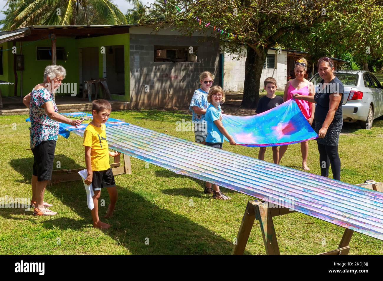 Les gens teindent du tissu pareu (une jupe enveloppante) sur un morceau de fer ondulé sur Rarotonga, une des îles Cook Banque D'Images