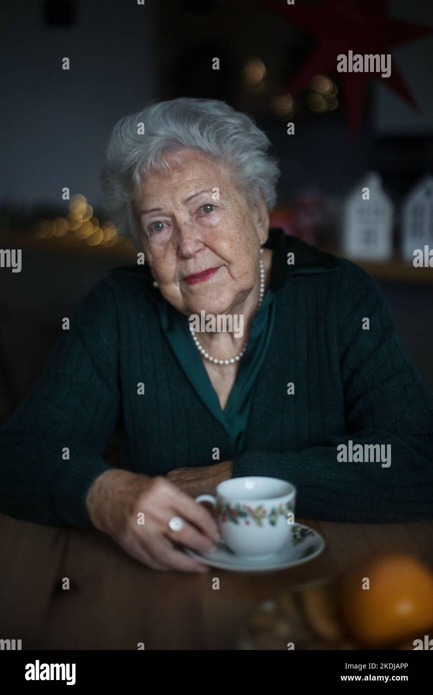Femme âgée malheureuse assise seule et attendant sa famille pendant la veille de Noël.concept de solitude, de santé mentale et de sénior. Banque D'Images