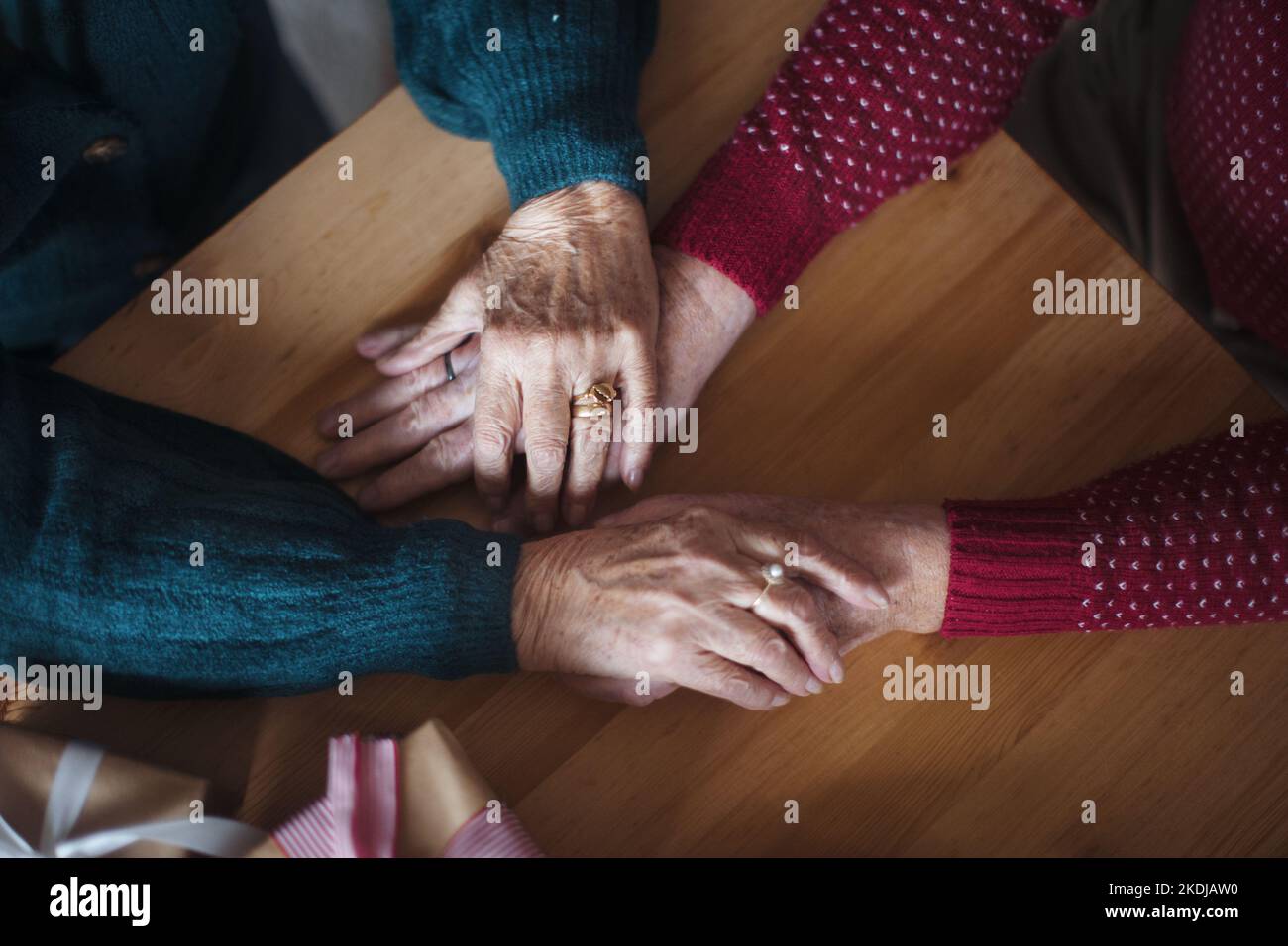 Vue de dessus des mains de couple de personnes âgées se tenant les unes les autres, pendant Noël. Banque D'Images