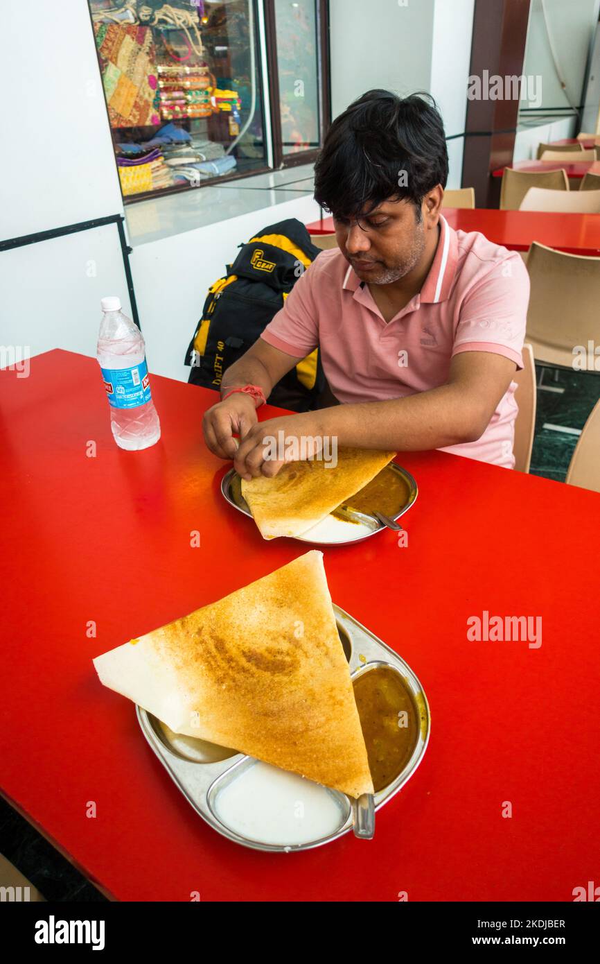 5 juillet 2022 Katra, Jammu-et-Cachemire, Inde. Un homme appréciant le masala dosa sud indien à la gare de Shri Mata Vaishno Devi Katra . Banque D'Images