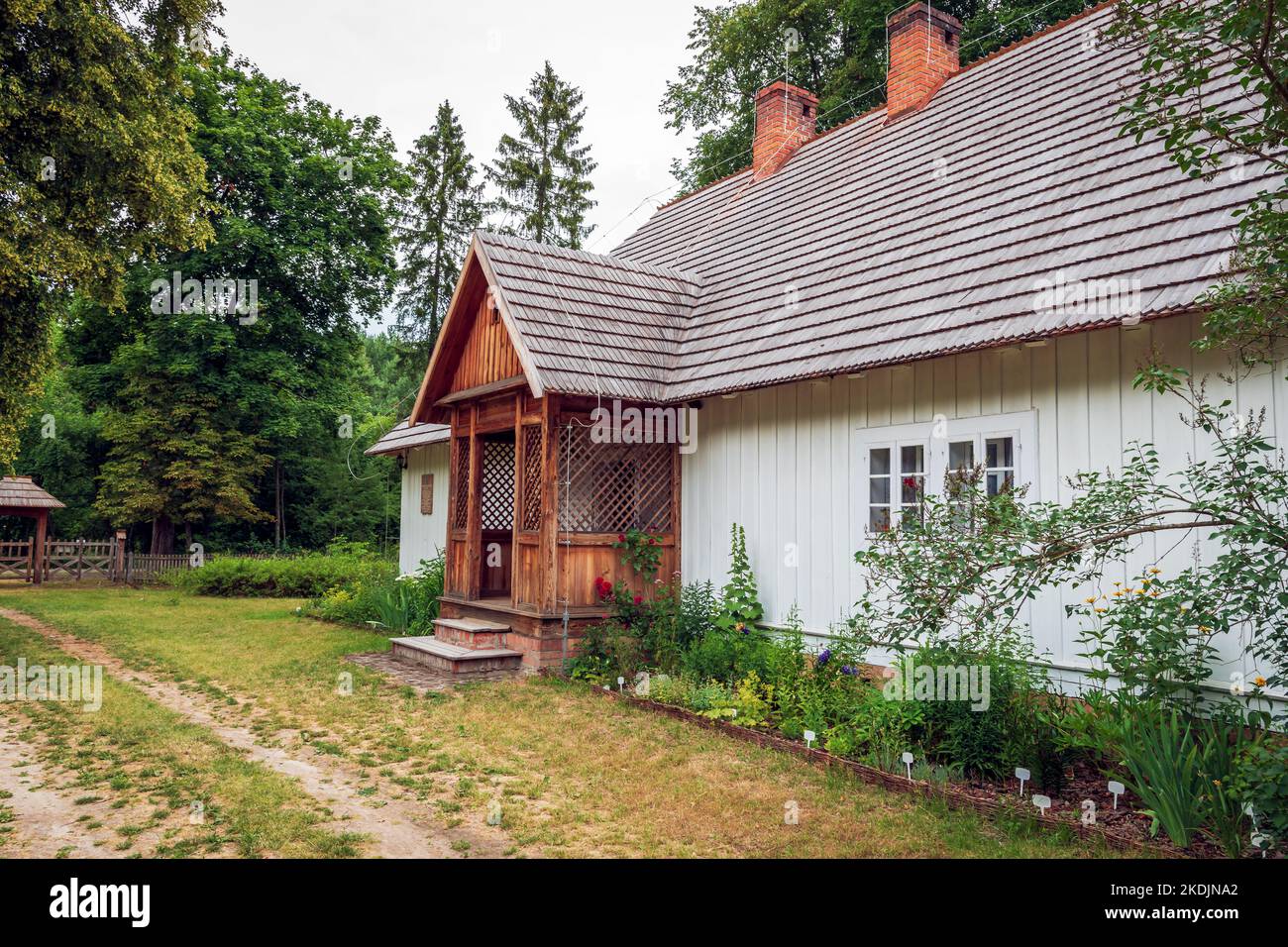 charmante maison de campagne avec un toit en galets et une véranda et un petit jardin. Zwierzyniec, Pologne Banque D'Images