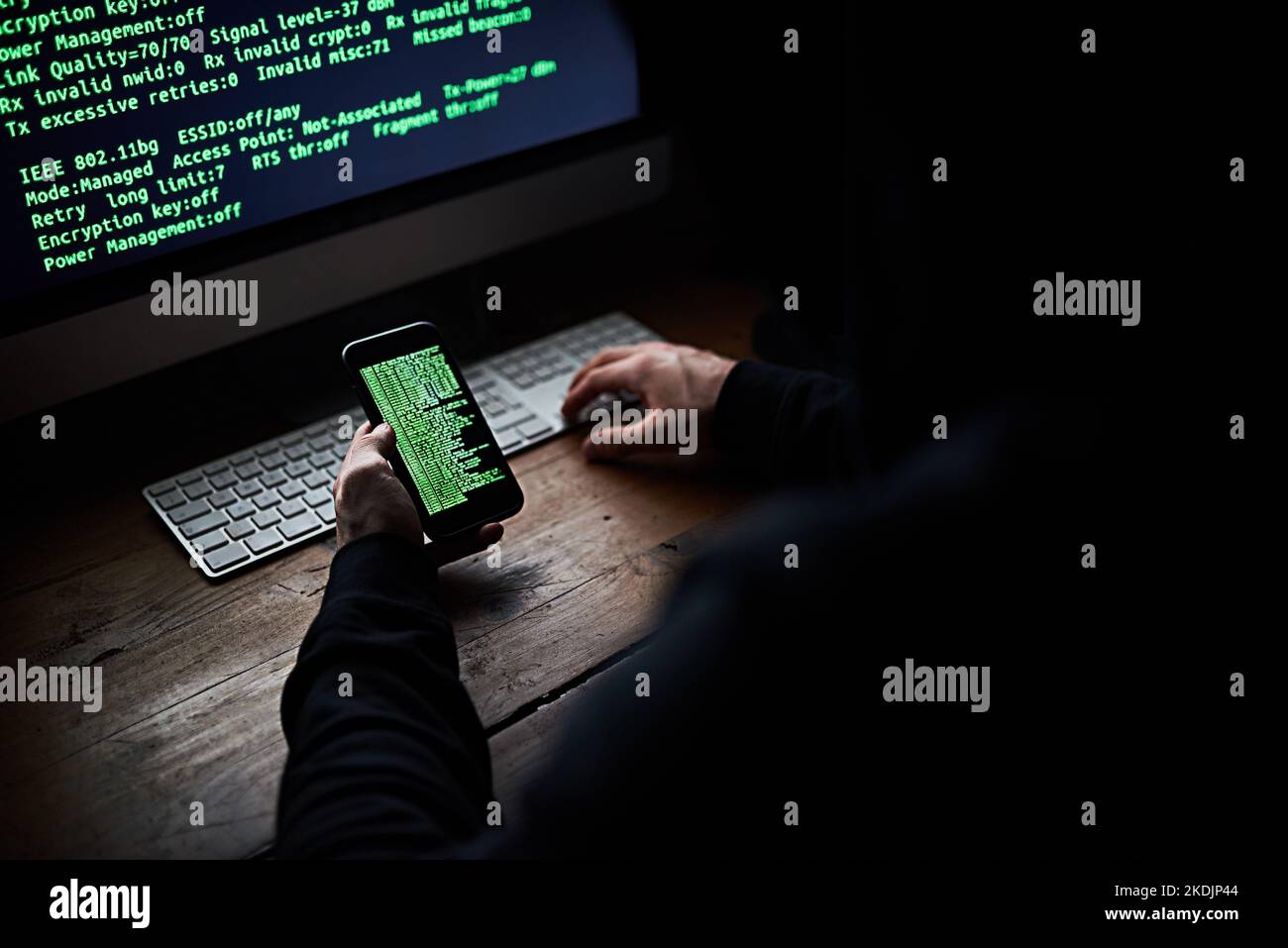 À la recherche de vos mots de passe. Prise de vue en grand angle d'un hacker non identifiable à l'aide d'un ordinateur tard dans la nuit. Banque D'Images