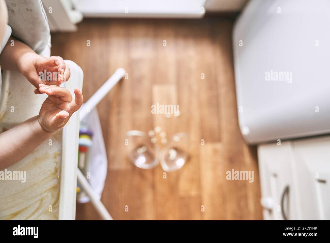Un petit bébé sur une chaise haute a déposé une tasse de soupe de nouilles sur le parquet. La plaque transparente est divisée en deux parties. Nouilles sous forme de chiffres. La table est sale. Photo de haute qualité Banque D'Images Un petit bébé sur une chaise haute a déposé une tasse de soupe de nouilles sur le parquet. La plaque transparente est divisée en deux parties. Nouilles sous forme de chiffres. La table est sale. Photo de haute qualité Banque D'Images