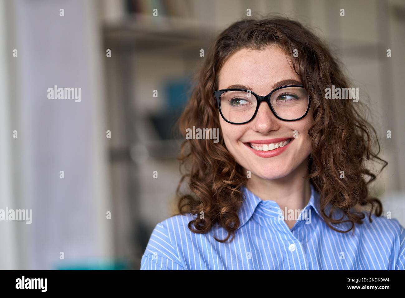 Jeune femme d'affaires professionnelle souriante et intéressée qui regarde loin de l'espace de copie. Banque D'Images