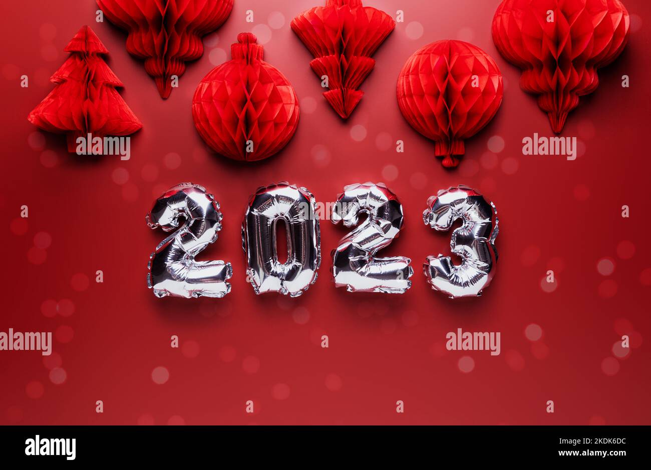 Arrière-plan de Noël ou du nouvel an. Couleur rouge bordeaux avec décorations et numéros de bordeaux argentés brillants de 2023. Copier la zone d'espace pour la publicité. Maquette simple de carte de vœux minimaliste Banque D'Images