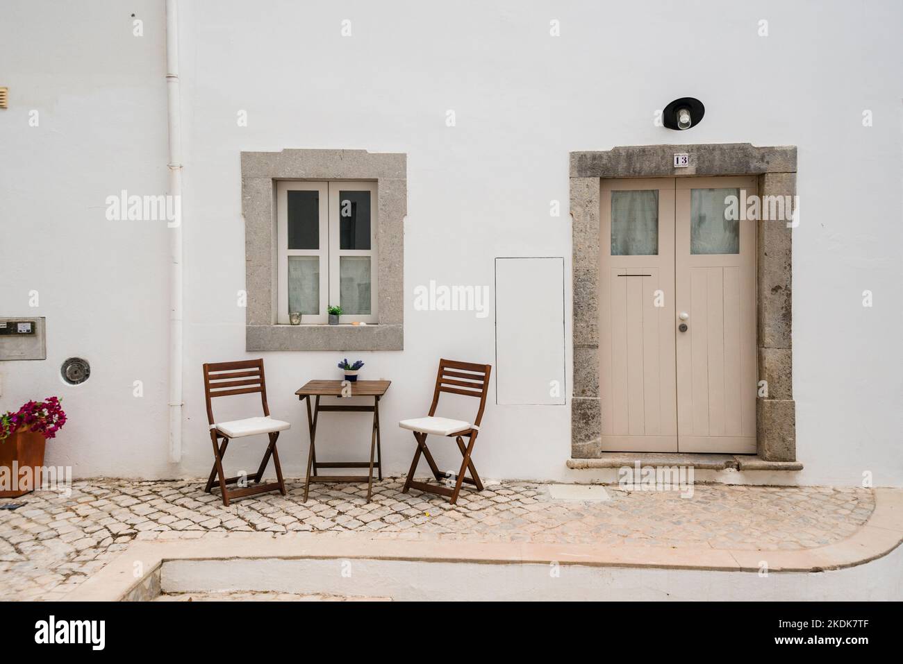 Deux chaises et une table mis à côté de la porte d'entrée de la maison, Tavira, Algarve, Portugal Banque D'Images