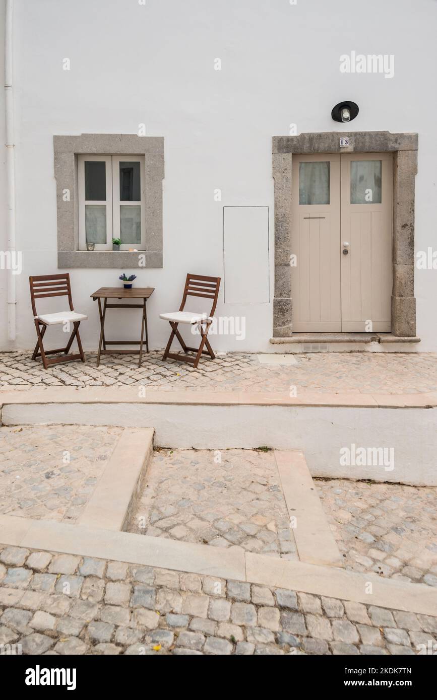 Deux chaises et une table mis à côté de la porte d'entrée de la maison, Tavira, Algarve, Portugal Banque D'Images