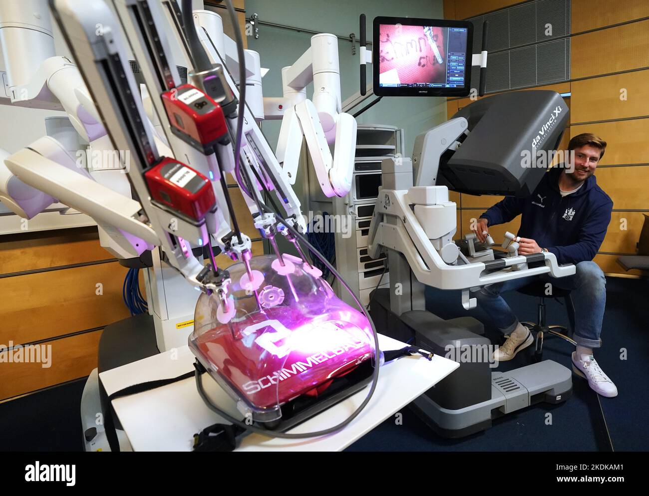 Hambourg, Allemagne. 07th novembre 2022. Tobias Schimmelbauer, joueur au Handball Sport Verein Hamburg (HSVH), signe un maillot à l'Asklepios Klinik Altona avec un robot chirurgical Da Vinci moderne. Le robot est utilisé pour des opérations urologiques compliquées. La campagne a pour but de sensibiliser le public à la santé et aux soins préventifs des hommes dans le cadre de la campagne « Movember ». Credit: Marcus Brandt/dpa/Alay Live News Banque D'Images