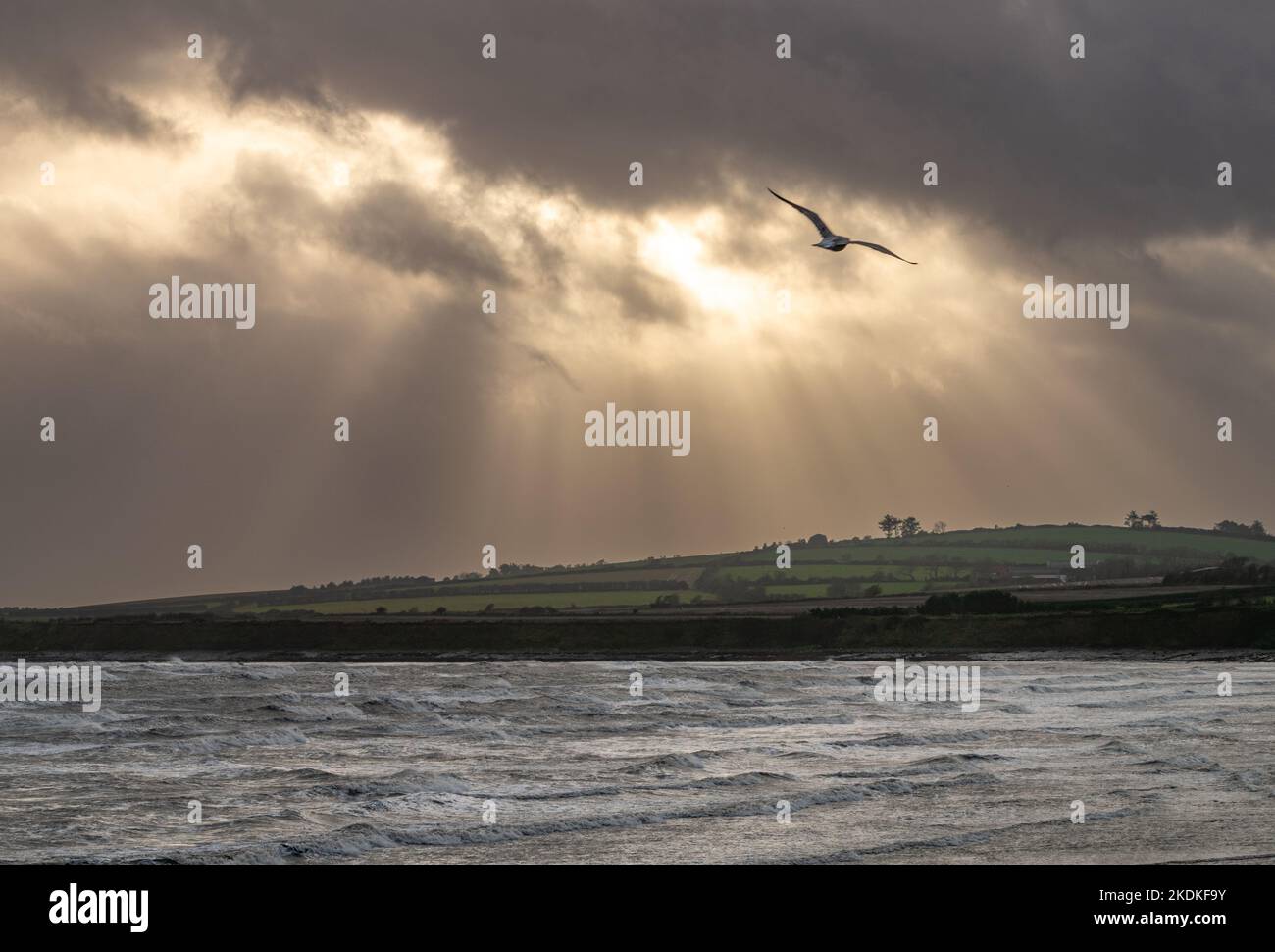Les rayons du soleil s'enflammant tandis que le soleil tente d'apparaître des nuages dans Skerries pendant Storm Barra Banque D'Images