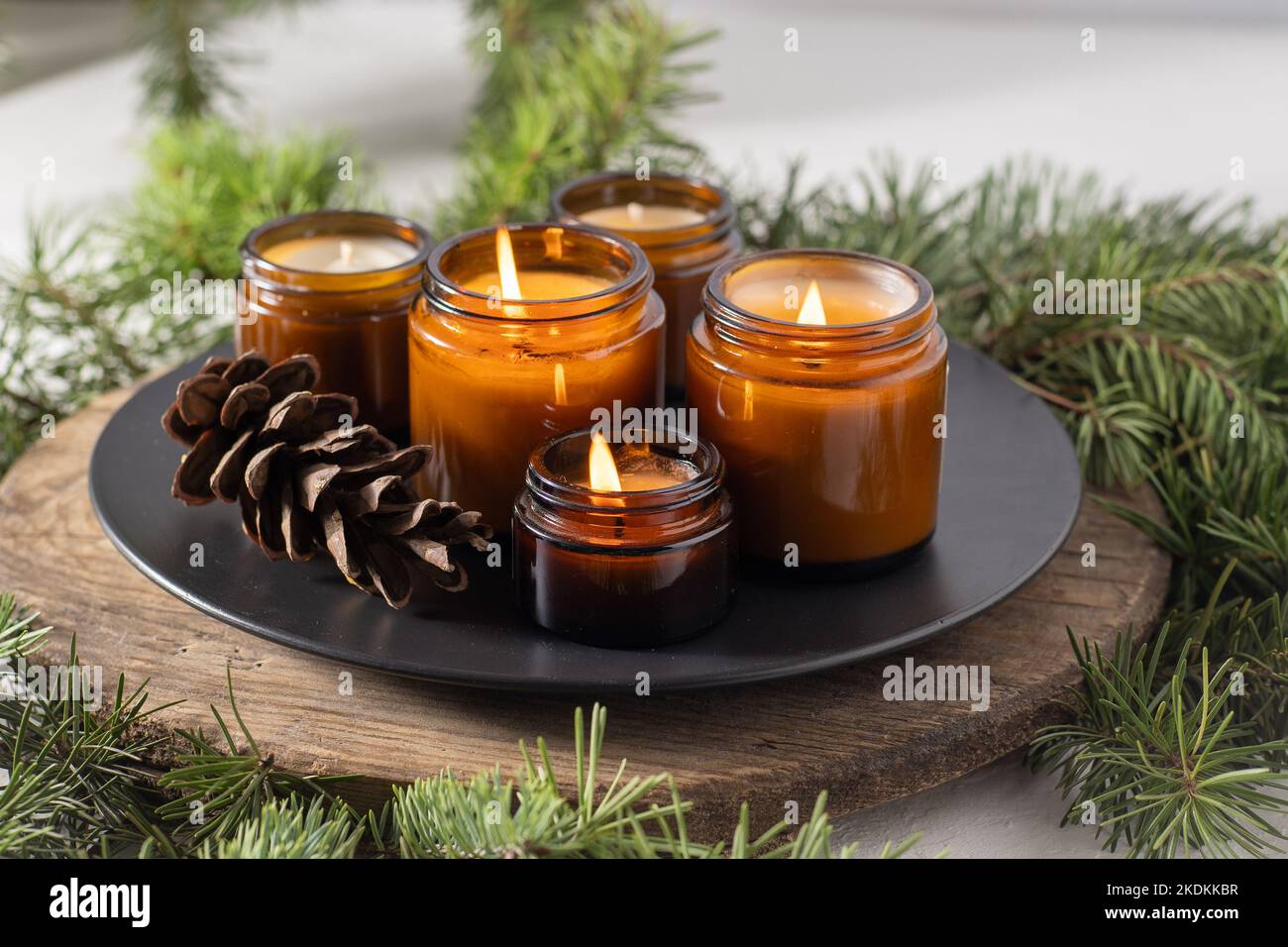 Les bougies de soja brûlent dans des pots en verre. Confort à la maison. Bougie dans un pot brun. Parfum et lumière. Bougie parfumée faite à la main. Aromathérapie. Arbre de Noël et ambiance d'hiver. Décoration chaleureuse. Décoration de fête Banque D'Images