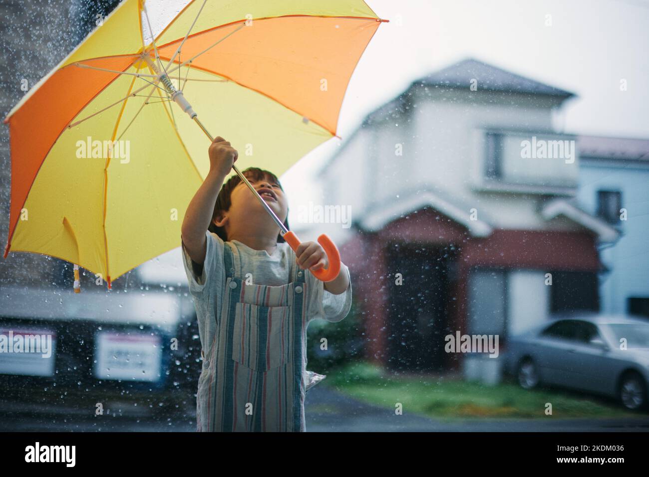 Enfant japonais jouant dehors le jour des pluies Banque D'Images