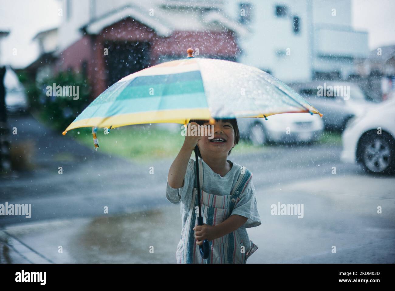 Enfant japonais jouant dehors le jour des pluies Banque D'Images