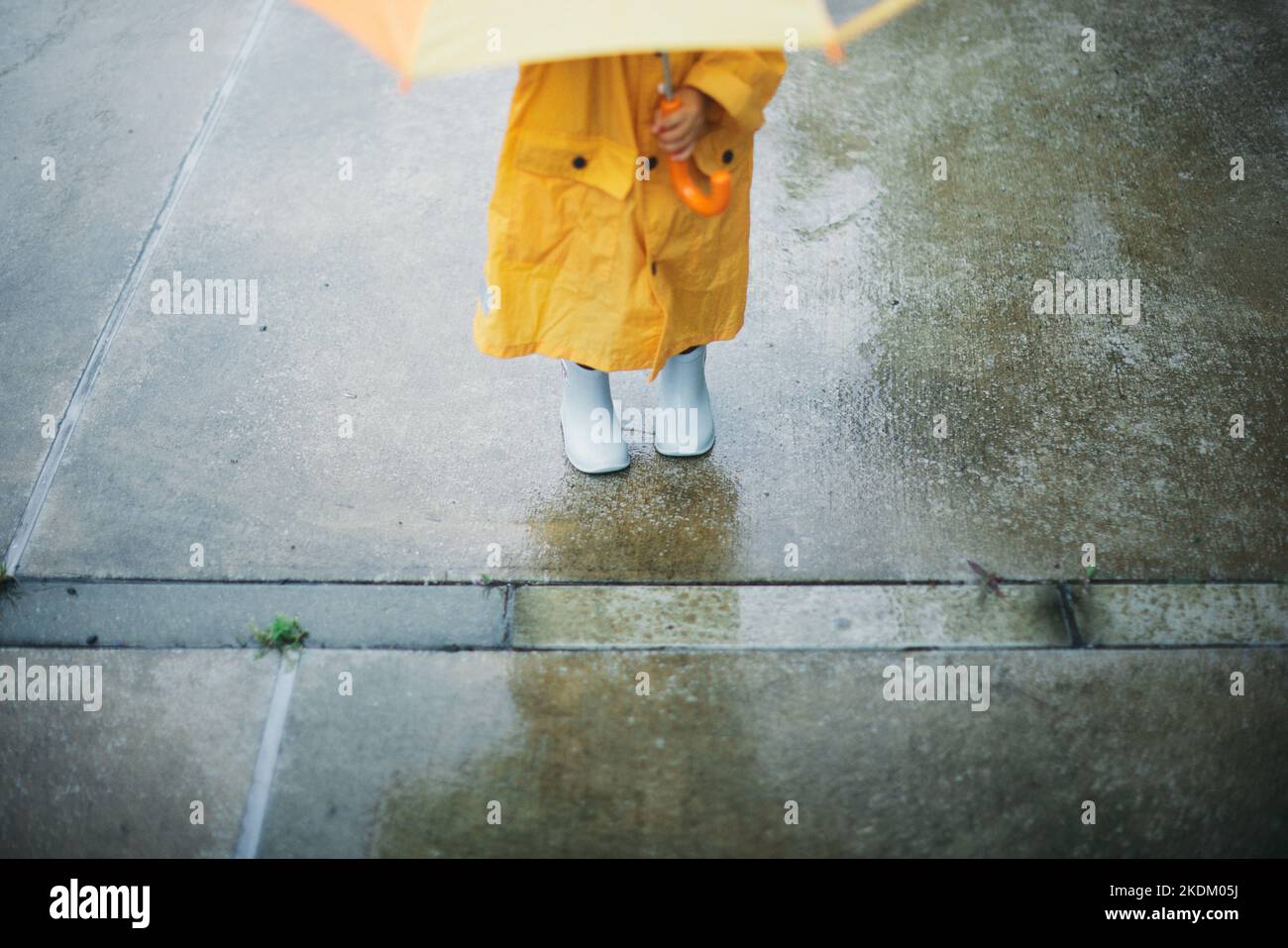 Enfant japonais jouant dehors le jour des pluies Banque D'Images