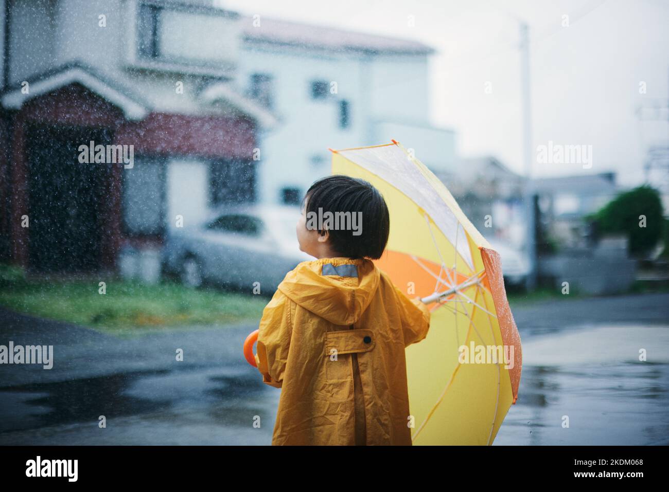 Enfant japonais jouant dehors le jour des pluies Banque D'Images