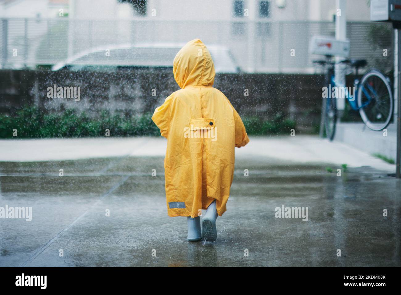 Enfant japonais jouant dehors le jour des pluies Banque D'Images