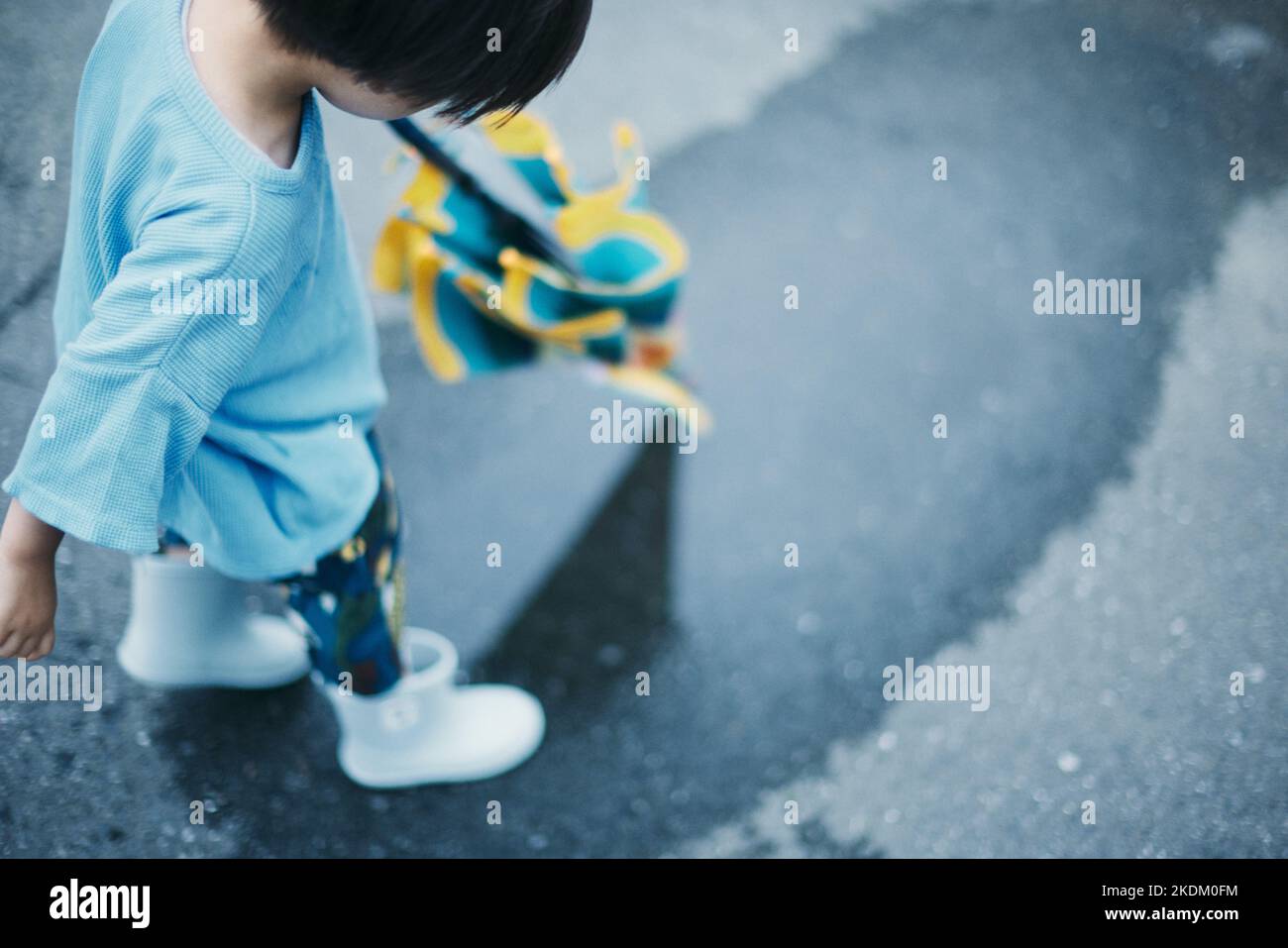 Enfant japonais jouant dehors le jour des pluies Banque D'Images