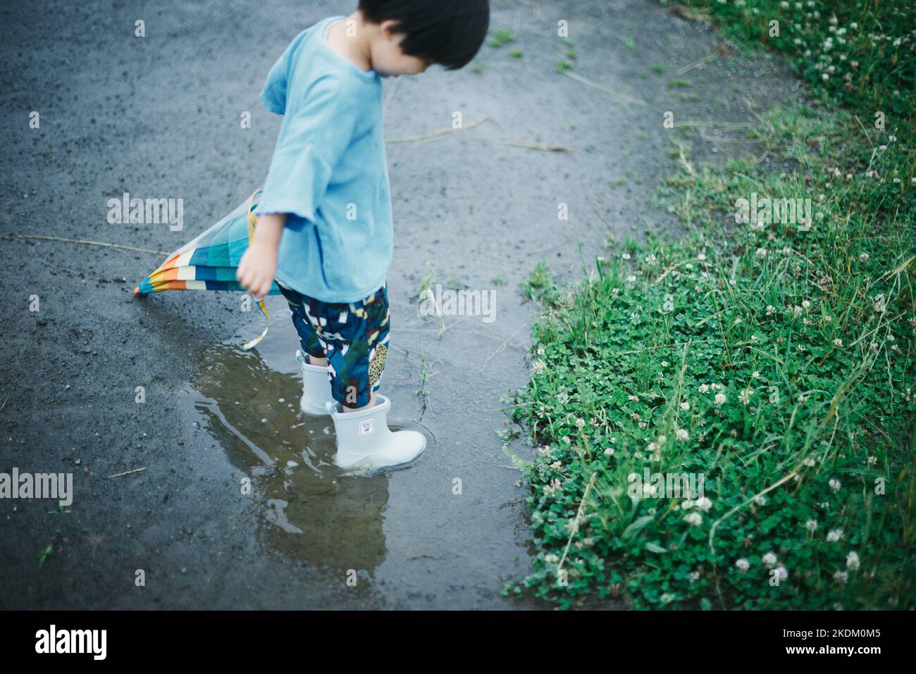 Enfant japonais jouant dehors le jour des pluies Banque D'Images