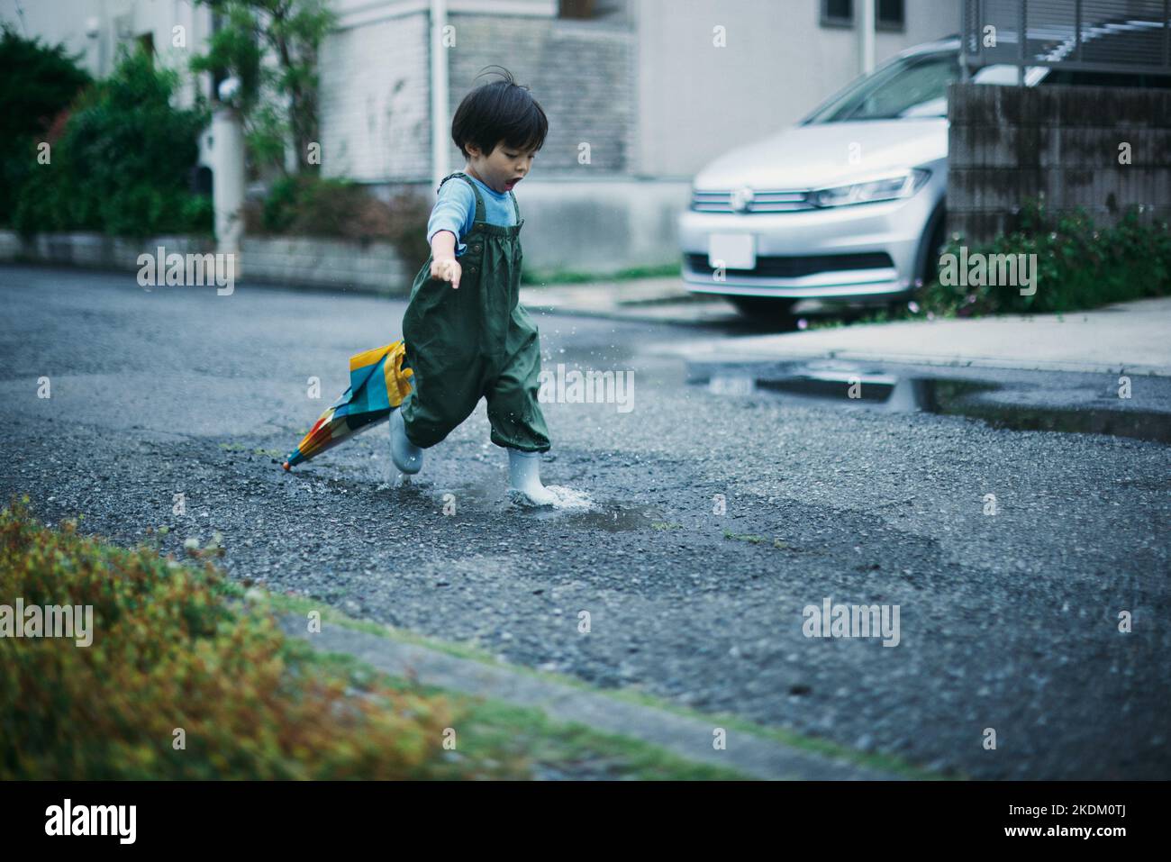 Enfant japonais jouant dehors le jour des pluies Banque D'Images