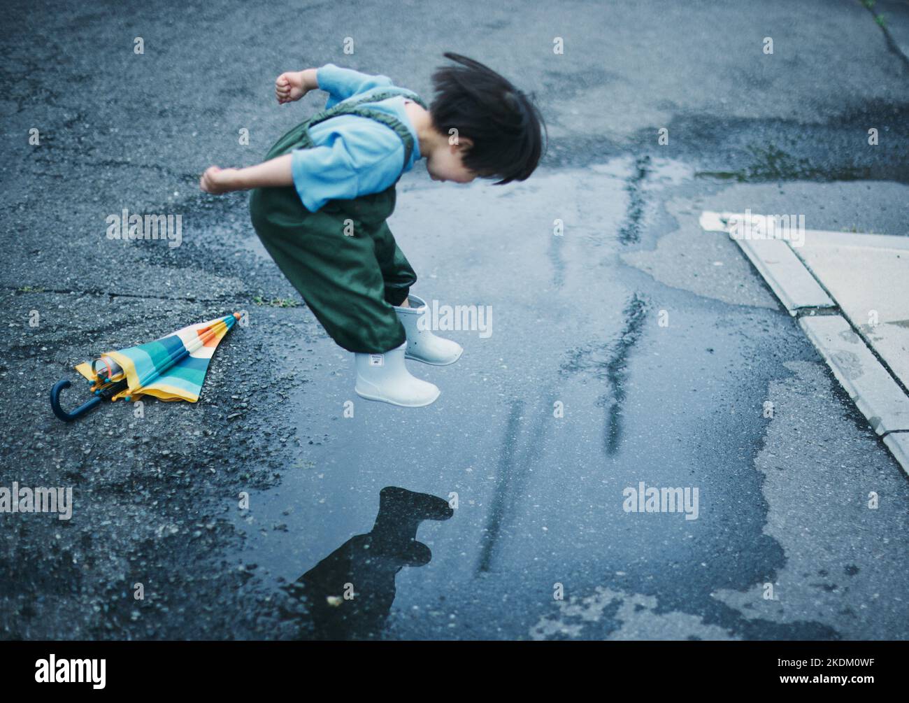 Enfant japonais jouant dehors le jour des pluies Banque D'Images