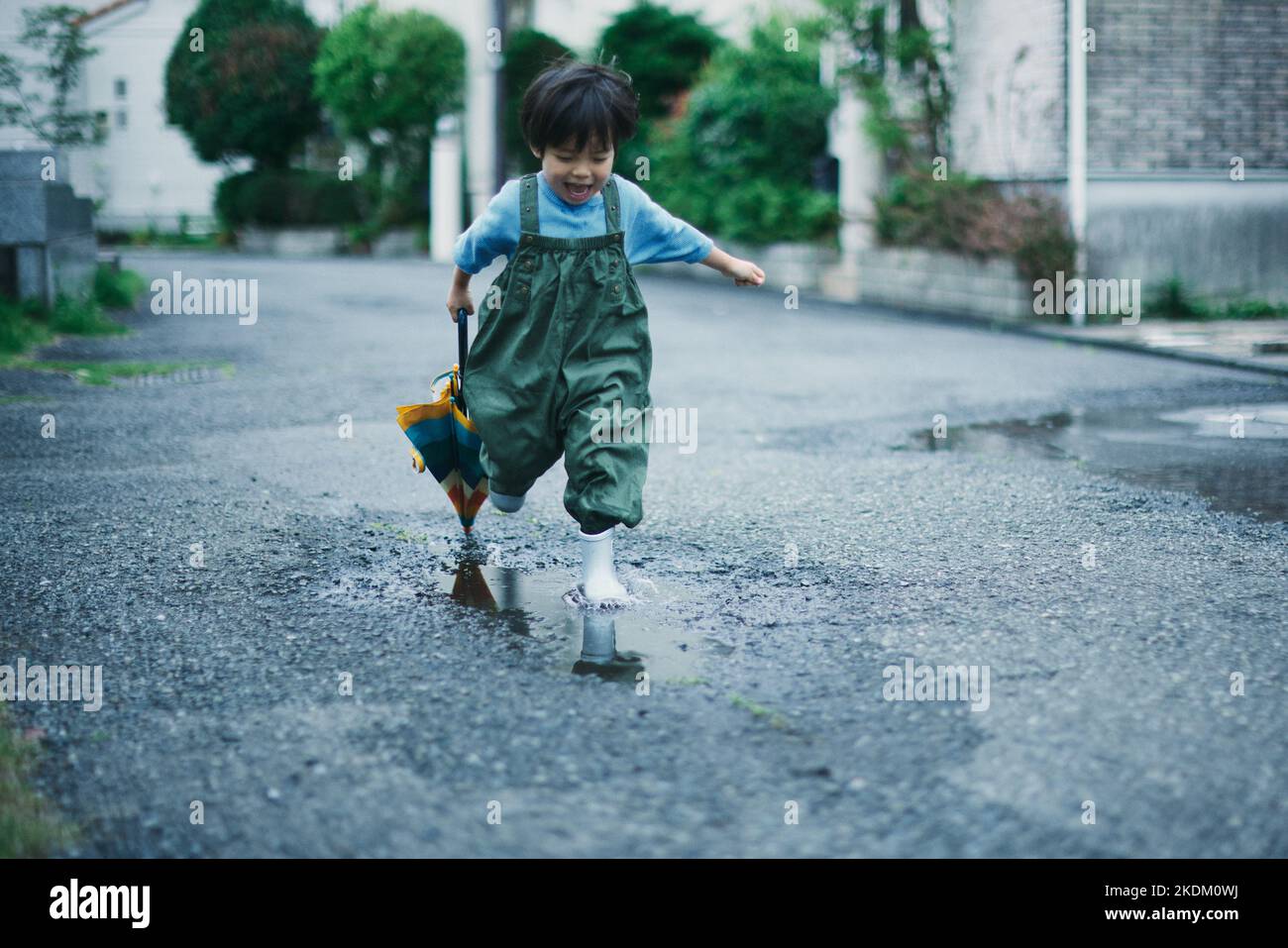 Enfant japonais jouant dehors le jour des pluies Banque D'Images
