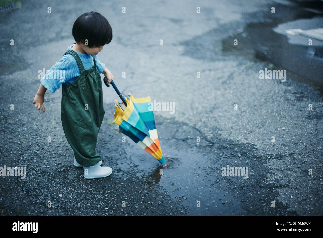 Enfant japonais jouant dehors le jour des pluies Banque D'Images